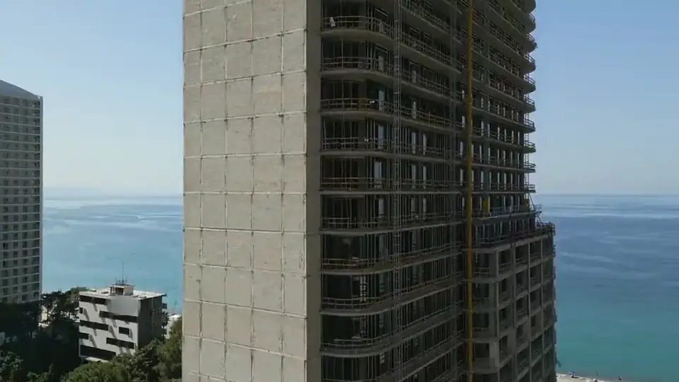 The tower close up, with the neighbouring hotel and the sea