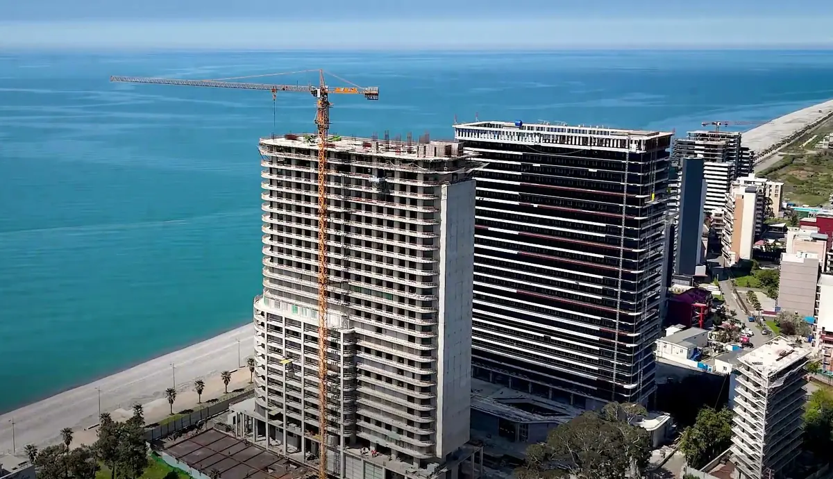 The tower under construction on the Gonio shoreline, filmed from a drone in June 2026